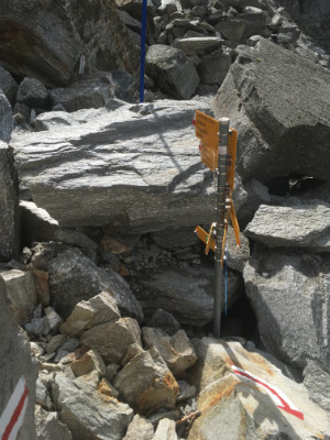 Hiking signs surrounded by large boulders in a boulder field